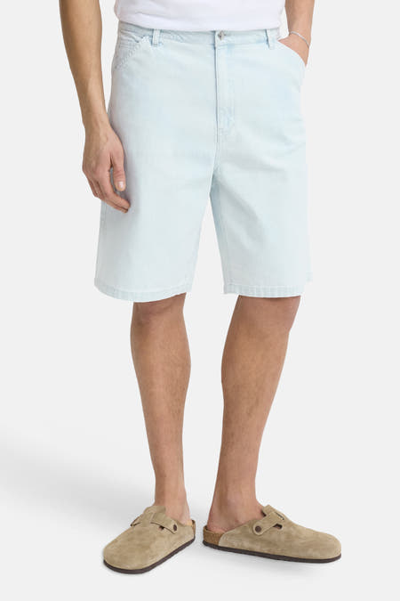 Lichtblauwe denim shorts van SOLID, front view, met zakken en geborduurde details, gedragen met wit shirt en bruine slippers