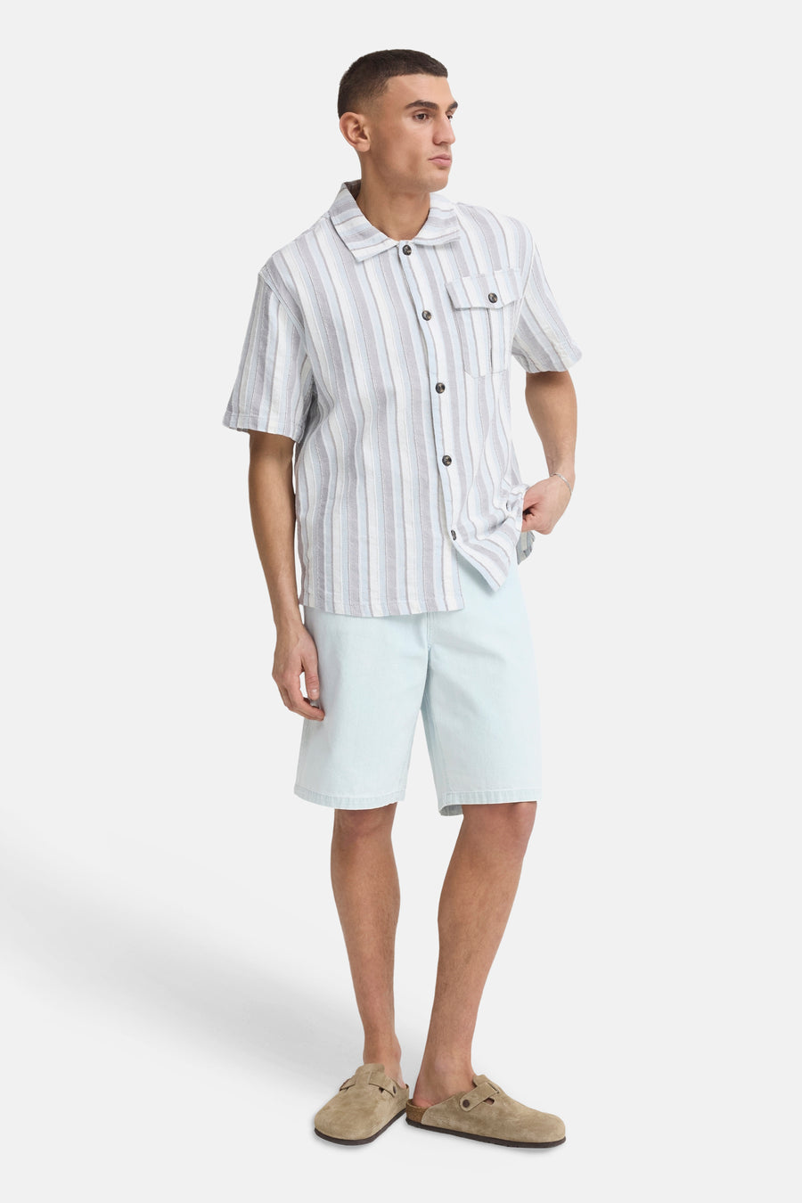 Lichtblauwe denim shorts van SOLID, rechte pasvorm, gedragen met gestreept overhemd en bruine slippers, volledige vooraanzicht.