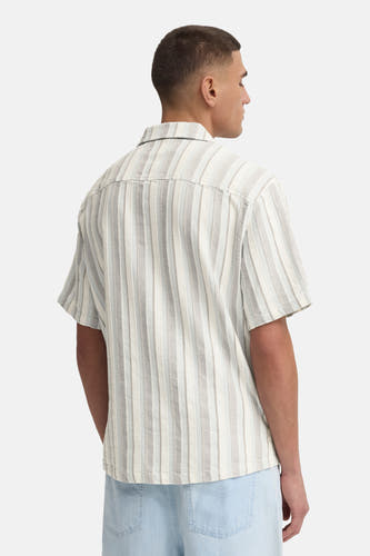 Chemise rayée multicolore à manches courtes de SOLID, texturée, portée sur un jean bleu clair à l'arrière.