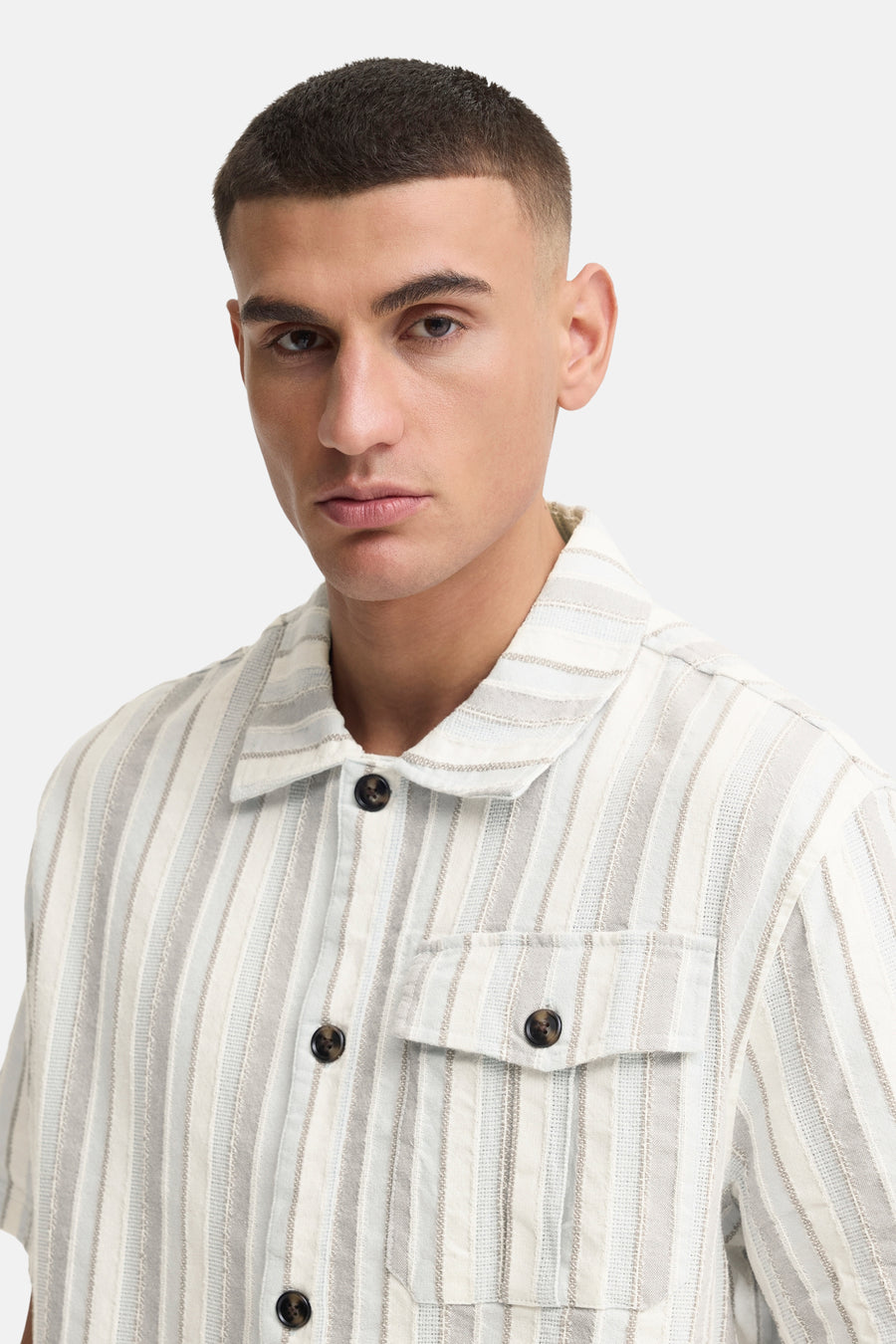 Chemise rayée multicolore à manches courtes de SOLID, avec col et poche poitrine, portée par un homme.