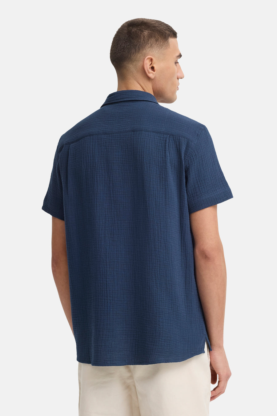 Chemise bleue à manches courtes de SOLID, avec texture crêpe, vue de dos, portée sur un pantalon clair.