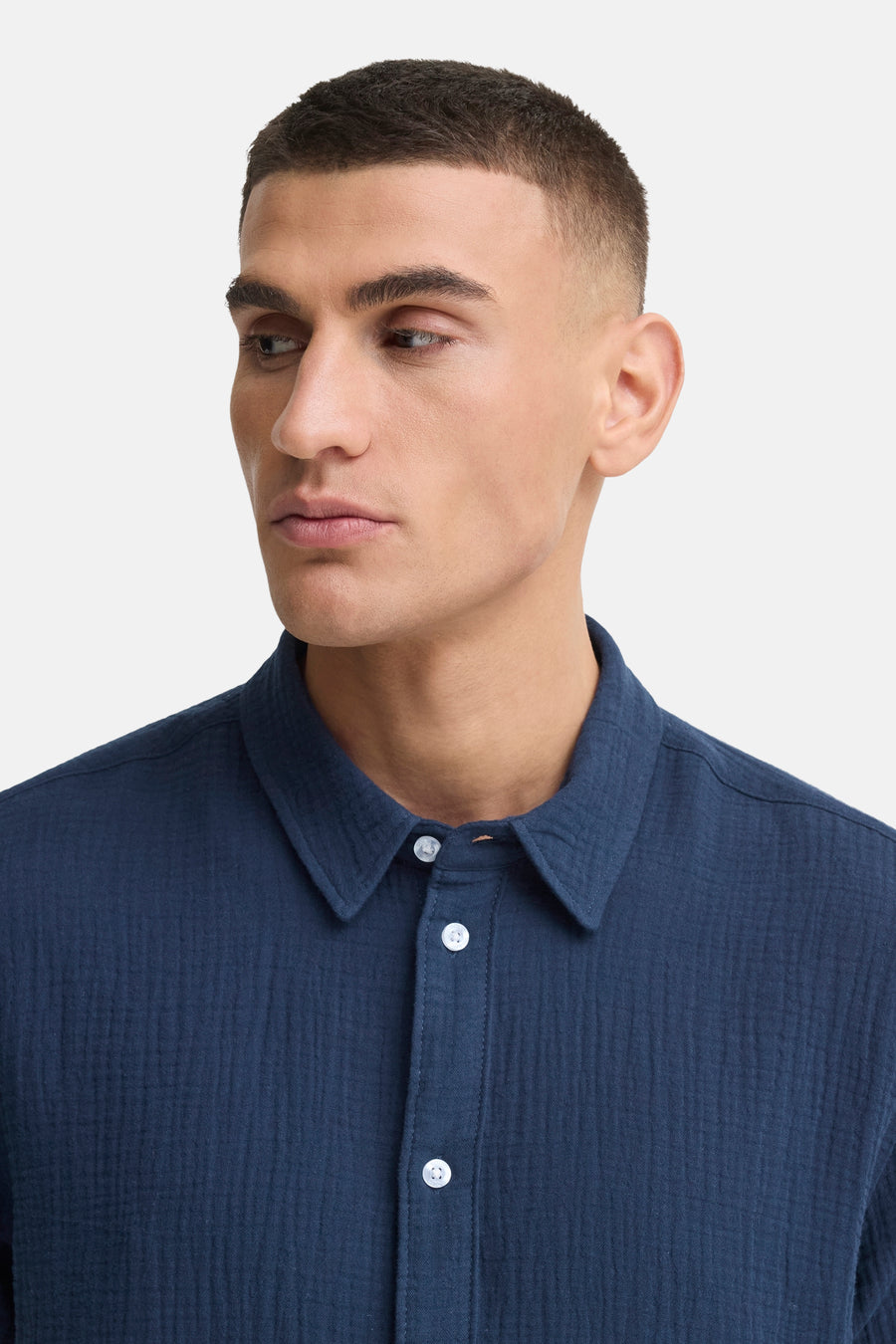 Chemise bleue de SOLID avec tissu texturé et boutons blancs, portée par un homme.
