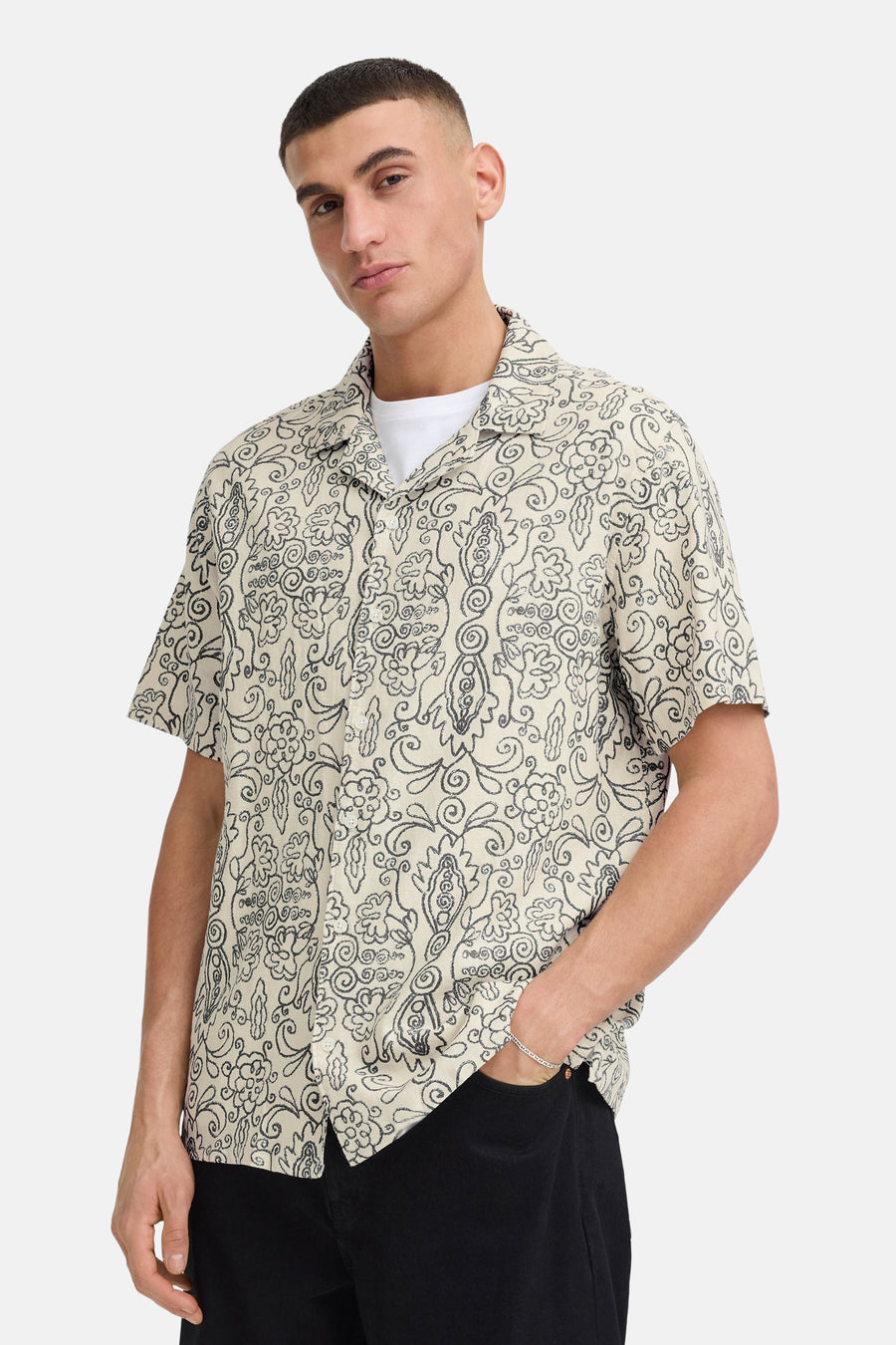 Chemise écru à manches courtes de SOLID, avec motif organique foncé et col ouvert, portée sur un t-shirt blanc.