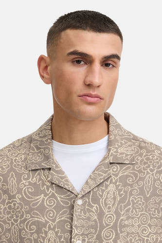Bruin hemd met korte mouwen van SOLID, met een crème bloemen- en bladmotief, gedragen over een wit T-shirt.