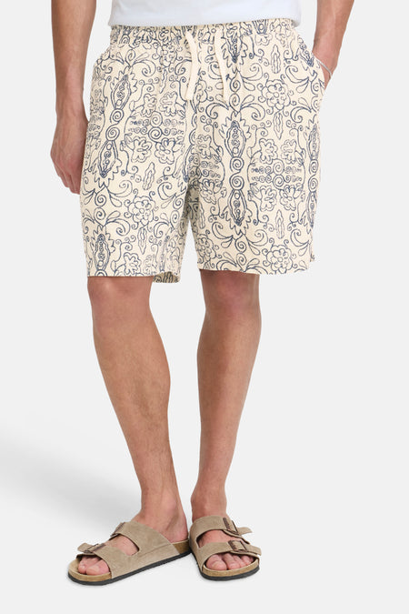 Short de couleur crème de SOLID avec un motif abstrait bleu brodé, vu de dos.