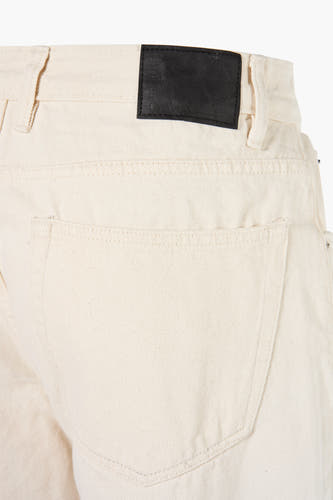 Jean droit écru de REDEFINED REBEL, avec une étiquette de marque en cuir à l'arrière.