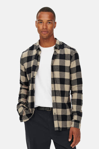 Chemise bleue à manches longues de ONLY & SONS®, avec un motif en damier beige et noir, portée sur un T-shirt blanc avec un pantalon noir.