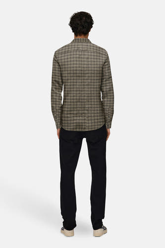 Chemise brune à longues manches de ONLY & SONS®, avec un motif à carreaux, associée à un pantalon noir et des baskets crème.