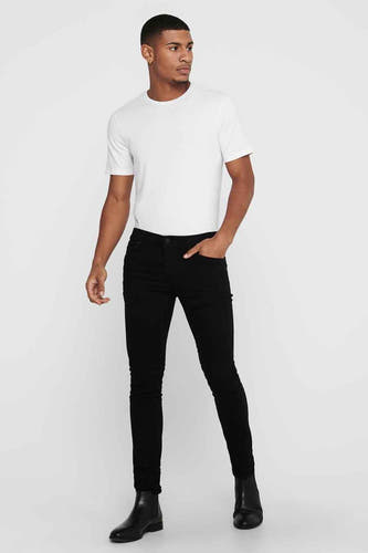 Jean slim noir de ONLY & SONS, avec un homme portant un T-shirt blanc et des chaussures noires.