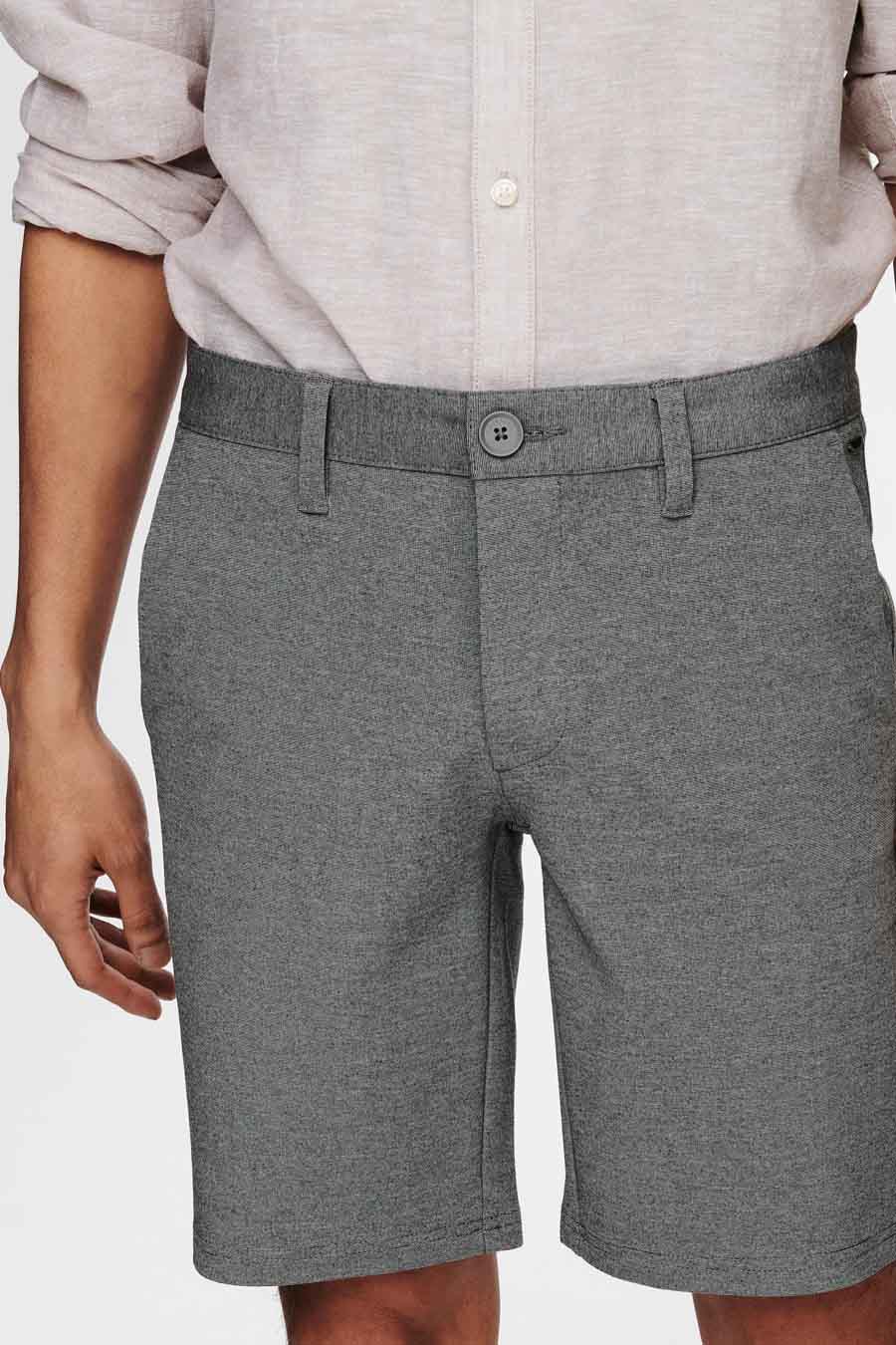 Veste grise d'ONLY & SONS, avec des passants et une fermeture à boutons, associée à un chemisier beige.