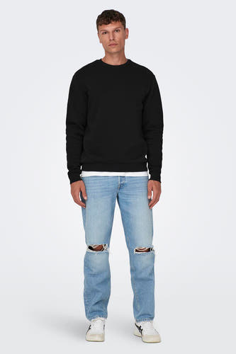 Pull-over noir d'ONLY & SONS, avec des manches longues et un col rond, porté sur une chemise blanche et un jean.