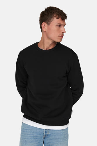 Zwarte sweater van ONLY & SONS, met lange mouwen en ronde hals, gedragen over een wit shirt en een jeans.