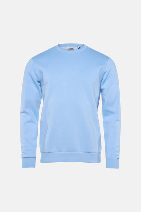 Pull-over bleu avec col rond de ONLY & SONS®, associé à des jeans et des baskets blanches.