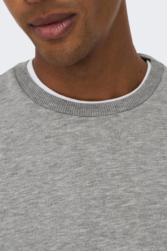 Prise de vue rapprochée d'un sweatshirt gris melange avec une encolure blanche.