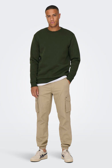 Pull-over vert en ONLY & SONS, porté avec un T-shirt blanc et un pantalon cargo beige.