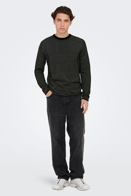 Pull noir à col rond de ONLY & SONS® avec un motif de petits pois blancs, porté avec un jean foncé et des baskets blanches, vue de face.