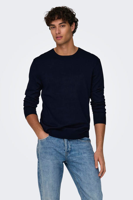 Pull bleu à col rond de ONLY & SONS, vu de dos sur un homme avec un t-shirt blanc, un pantalon foncé et des baskets claires.
