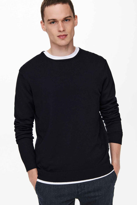 Pull col rond bleu marine de ONLY & SONS, porté sur un t-shirt blanc, avec poignets et ourlet côtelés.