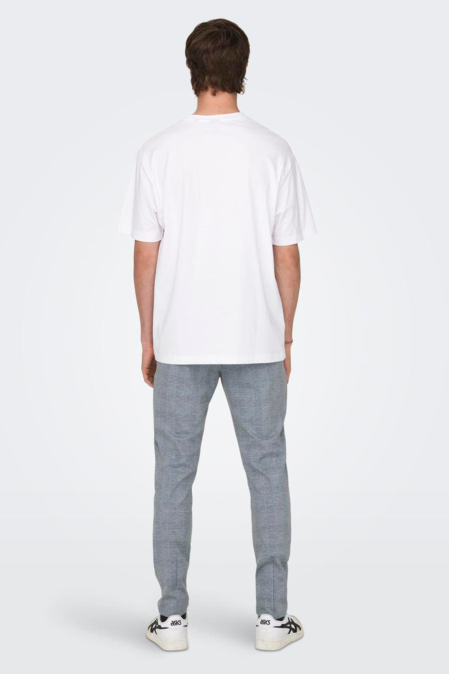 Wit T-shirt van ONLY & SONS, achterkant, gecombineerd met een grijze geruite broek en witte sneakers.