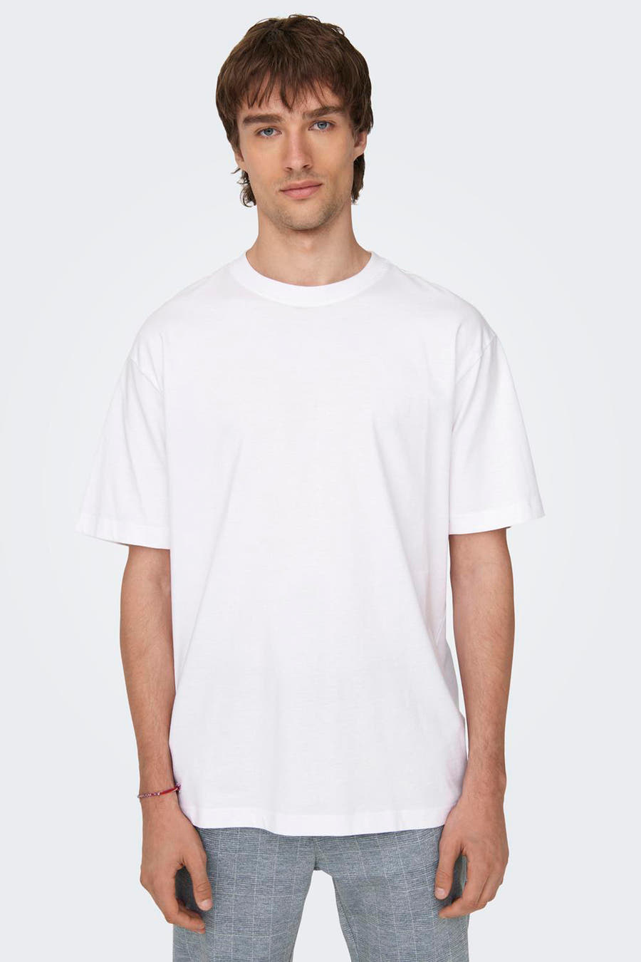 T-shirt blanc de ONLY & SONS®, à manches courtes, porté avec un pantalon large.