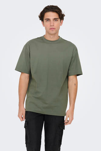 T-shirt vert avec manches courtes de ONLY & SONS, avec un tatouage minimaliste sur le bras et des pantalons noirs à poches.