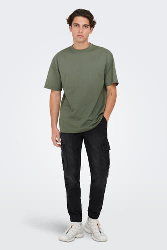 T-shirt vert avec manches courtes de ONLY & SONS®, porté avec un pantalon cargo noir et des baskets blanches.