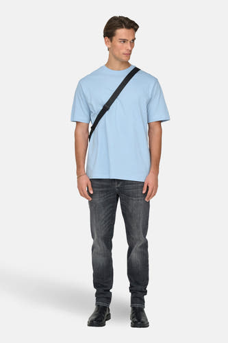T-shirt bleu à manches courtes de ONLY & SONS, avec une veste noire, des jeans gris et des bottes noires.