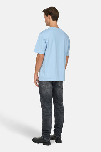 T-shirt bleu à manches courtes de ONLY & SONS, avec un homme portant des jeans noirs et des chaussures noires, vu de dos.
