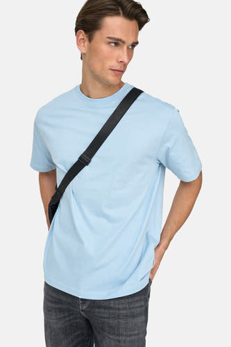 T-shirt bleu à manches courtes de ONLY & SONS®, porté avec un sac à dos et des jeans gris.