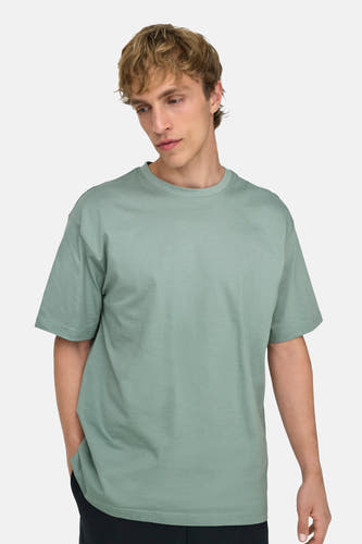 T-shirt vert de ONLY & SONS®, porté par un homme avec une main dans sa poche.