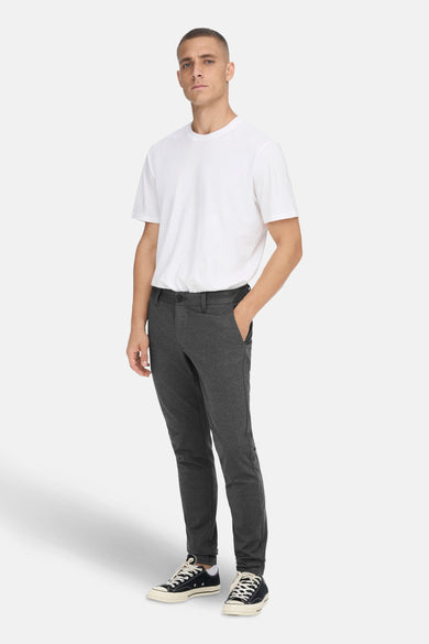 Pantalon gris d'ONLY & SONS, avec poche, associé à un T-shirt blanc et des baskets noires.