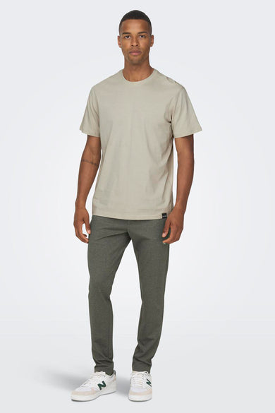 Pantalon brun de ONLY & SONS, avec une subtile texture et associé à un T-shirt beige et des baskets blanches.