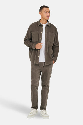 Chemise brune de ONLY & SONS®, à longues manches, portée sur un T-shirt blanc et un pantalon coordonné.