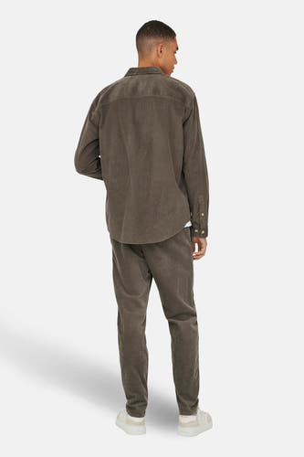 Chemise en corduroy marron de ONLY & SONS, à longues manches et coupe décontractée, associée à un pantalon en corduroy assorti et des baskets blanches.