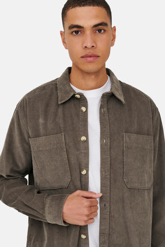 Chemise brune de ONLY & SONS, portée sur un T-shirt blanc, avec poches po poitrine et fermeture à boutons.