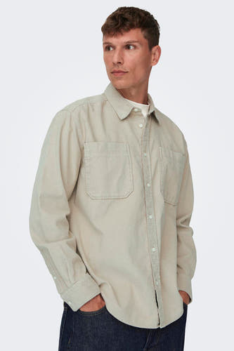 Chemise gris homme ONLY & SONS®, à longues manches, col boutonné et poches poitrine, portée sur un T-shirt blanc et des jeans foncés.