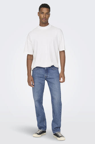 Jean en denim bleu de ONLY & SONS, porté avec un T-shirt blanc et des baskets noires.