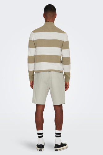 Man van achteren gezien, gestreepte trui, korte broek, sokken met strepen en sneakers.