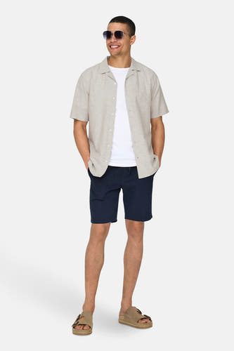 Chemise beige à manches courtes de ONLY & SONS, portée avec des shorts bruns et des baskets blanches.