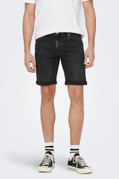 Short de jeans denim noir d'ONLY & SONS, avec des jambes retroussées, porté avec un t-shirt blanc et des baskets noires avec des chaussettes blanches, vue de dos.