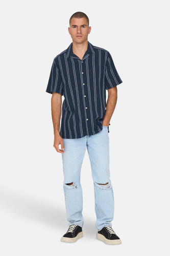 Chemise bleue à manches courtes de ONLY & SONS®, avec des rayures blanches et portée avec un pantalon en cuir.