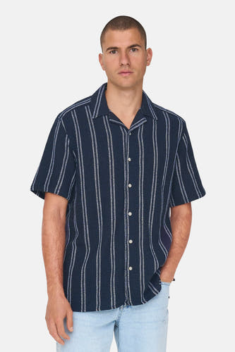 Chemise bleue rayée à manches courtes de ONLY & SONS, avec un col classique et une fermeture à boutons, portée avec un jean léger.