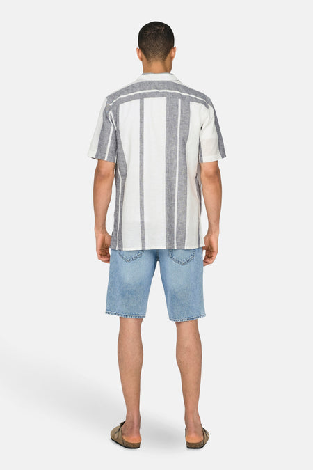 Chemise écru à manches courtes ONLY & SONS, à rayures verticales et associée à un short en jean.