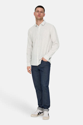Chemise beige à longues manches de ONLY & SONS, avec un motif rayé, associée à des jeans foncés et des baskets blanches.