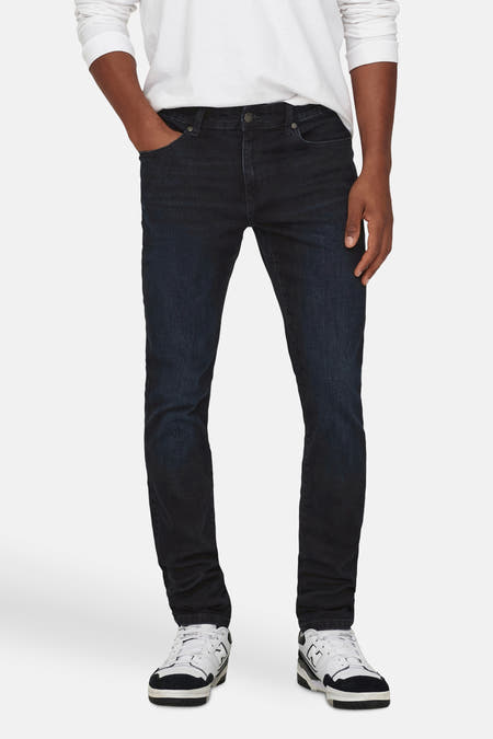 Jean slim de denim bleu marine d'ONLY & SONS, associé à un t-shirt blanc à manches longues et des baskets.