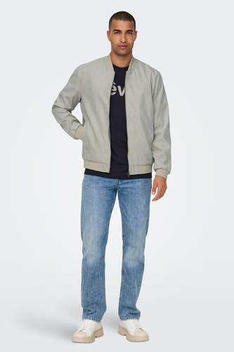 Manteau beige de ONLY & SONS®, avec des manches longues et un jeans bleu.