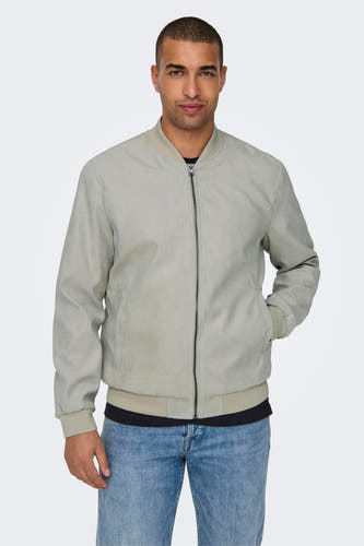 Manteau court beige de ONLY & SONS, avec une fermeture éclair et porté sur un t-shirt noir et des jeans bleus.