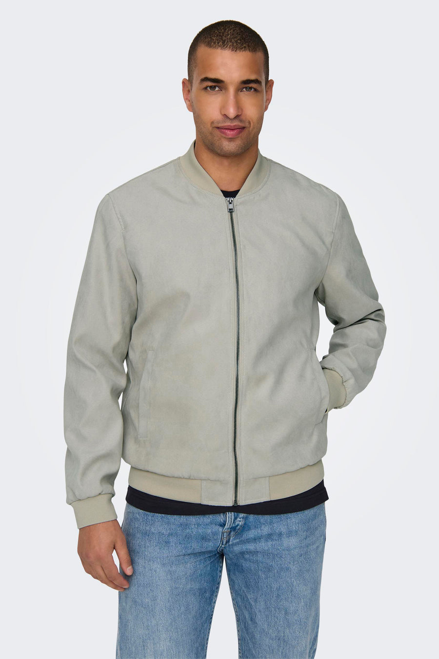 Man met grijze bomberjack en blauwe jeans.