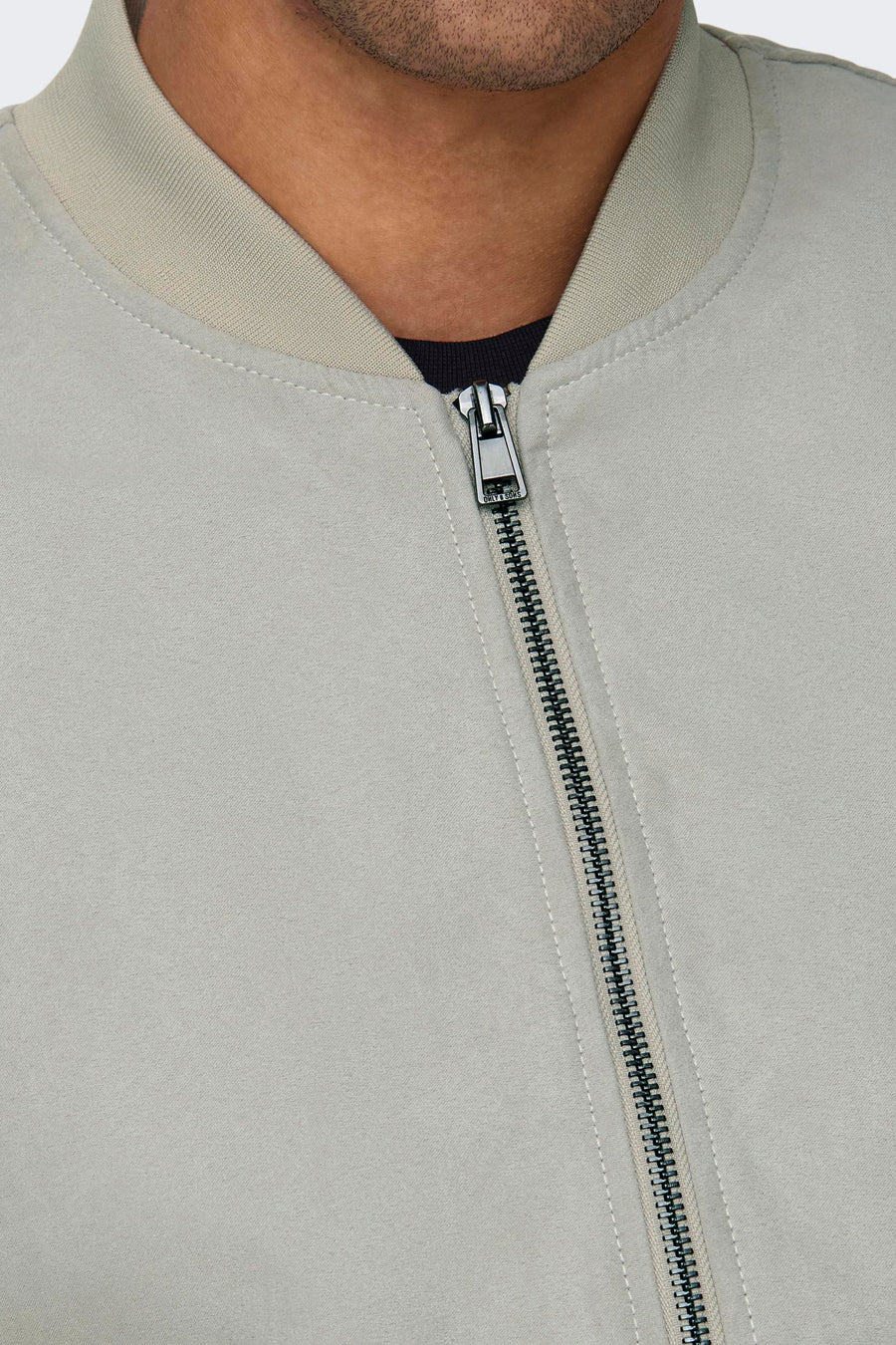 Beige bomberjack met ritssluiting.