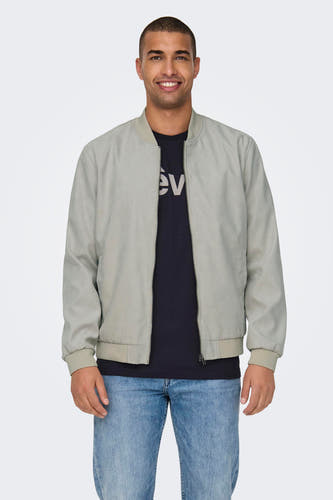 Manteau beige de ONLY & SONS®, avec un t-shirt noir et des jeans bleus.